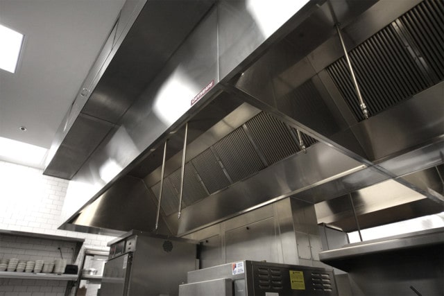 APS-Hoods technician performing restaurant exhaust fan cleaning and maintenance service in commercial kitchen Denver Colorado