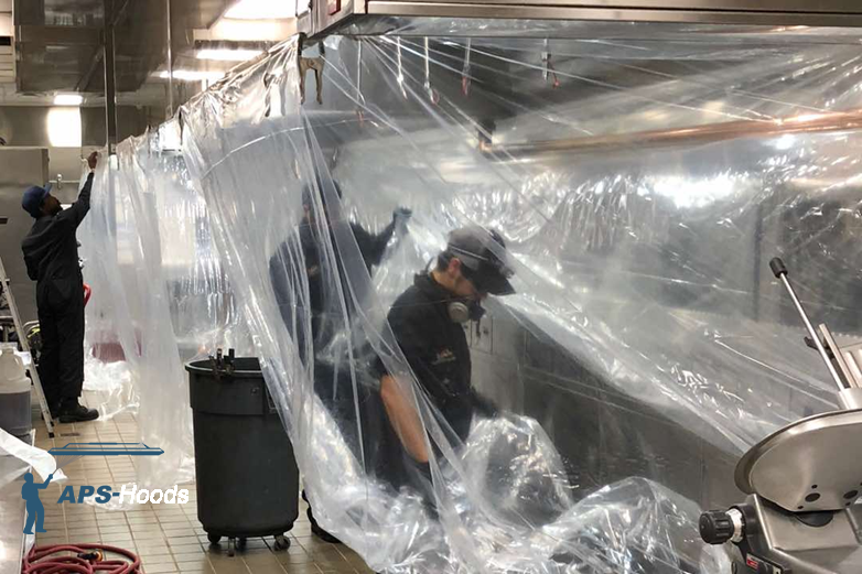 Protective plastic wraps and tarps covering kitchen appliances before professional hood cleaning service
